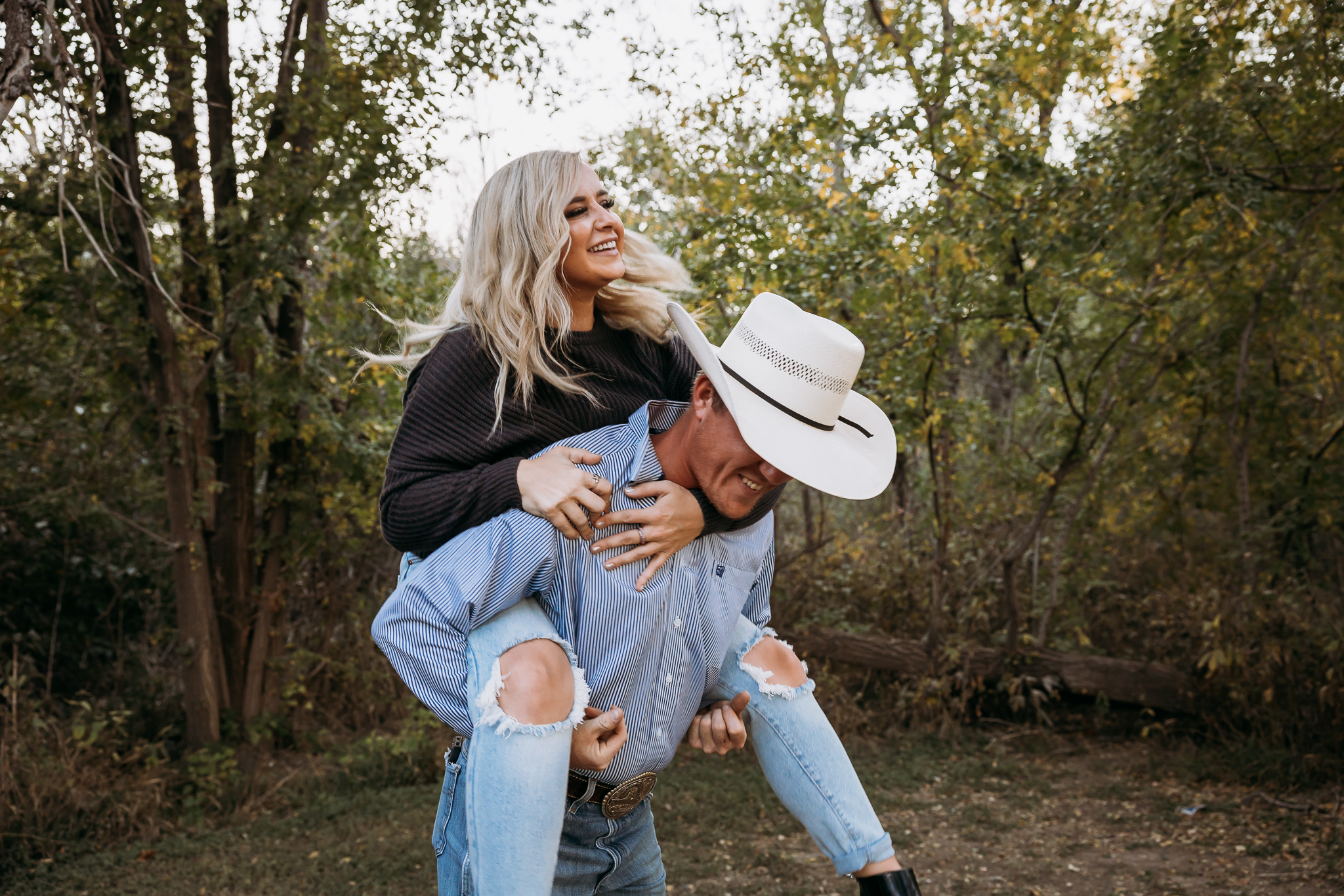 man and woman laughing piggy back ride